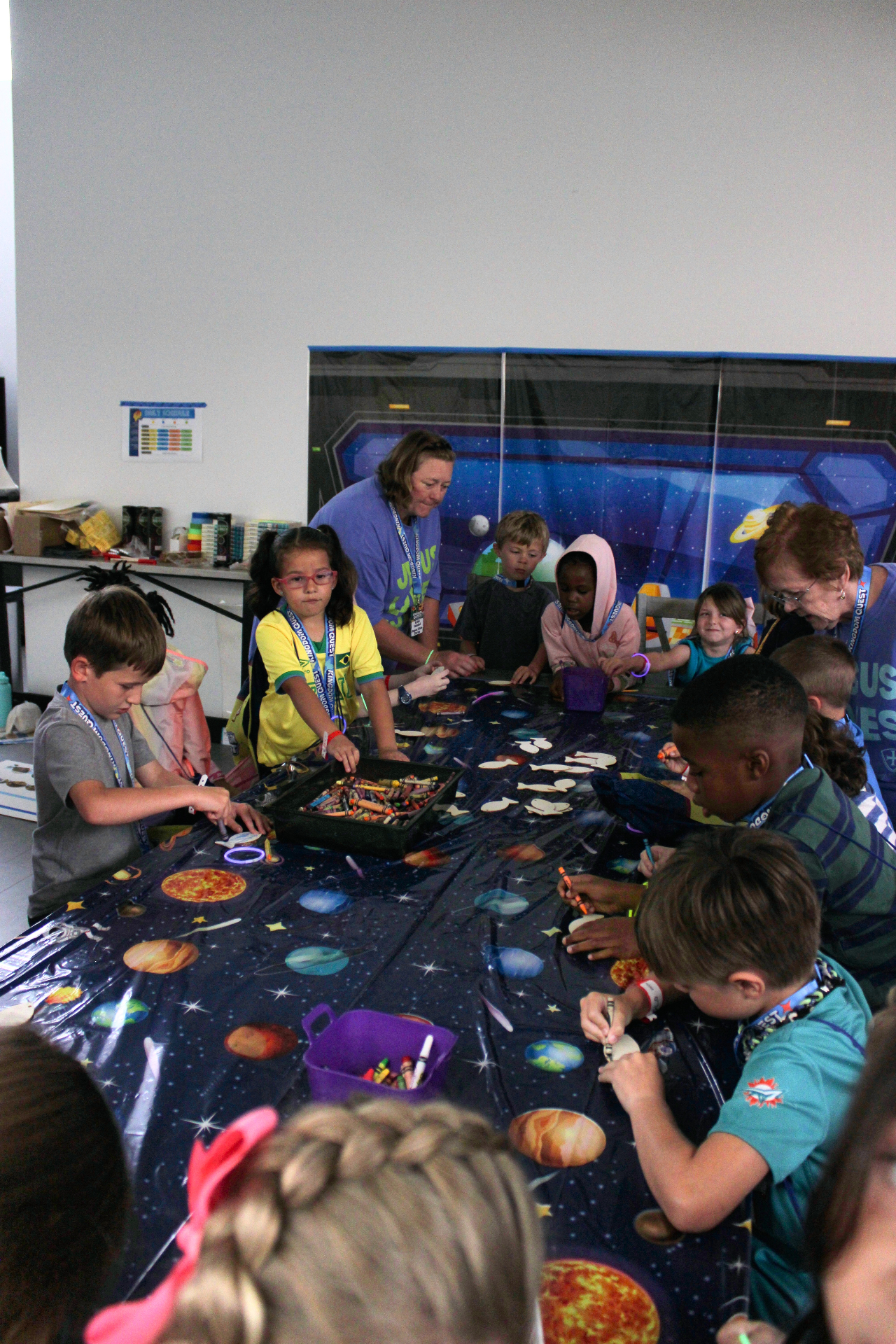 Volunteers helping children with a Kingdom Quest craft