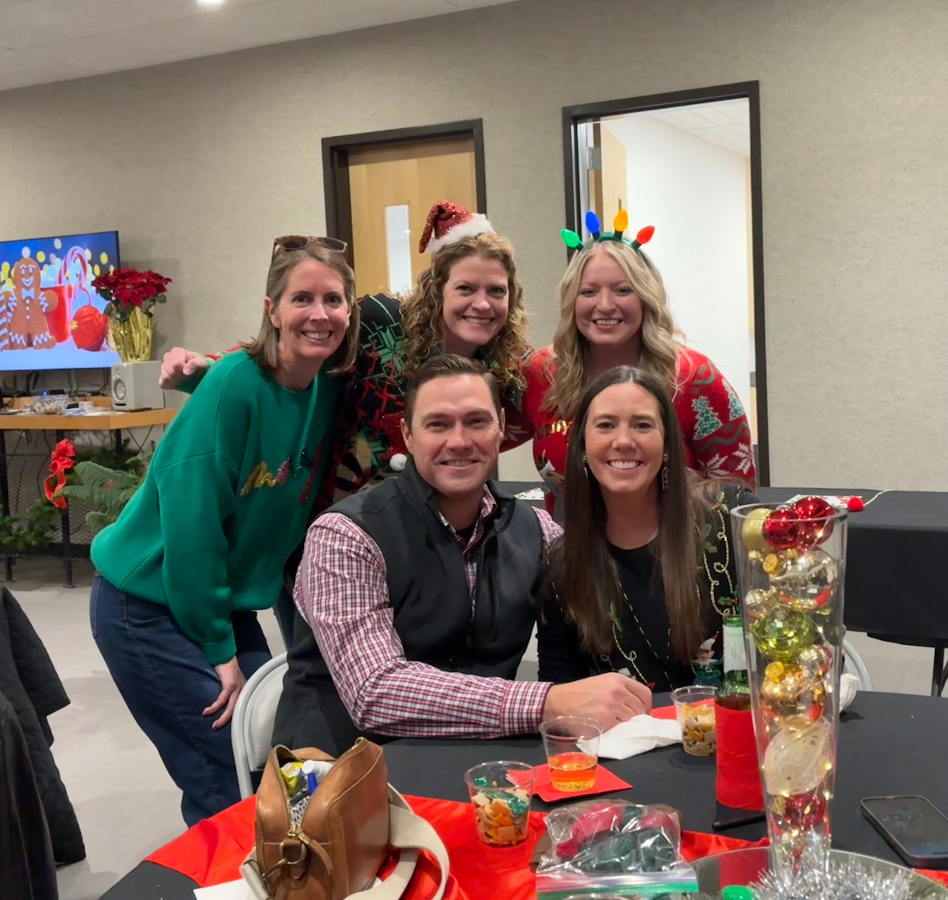 Friends smiling together at a decorated table during the Christmas party
