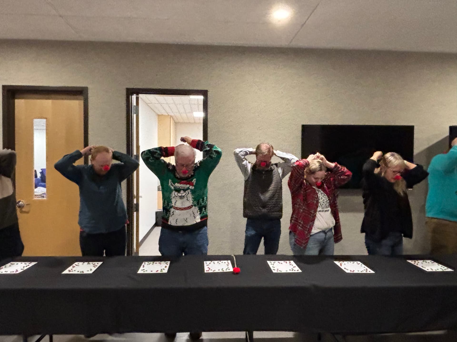 Party guests competing in a reindeer nose Christmas game